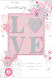 In this softly lit image, an anniversary card lies poised as if just placed next to a vase of fresh blooms in a Feltham home. The focal point is the word LOVE, rendered in raised, soft glitter that lends both texture and a quiet shimmer, with the letter O transformed into a delicate, silver-textured heart. The letters rest on a blush-pink background that feels warm and gentle, like evening light drifting over local gardens near Feltham's parks. Around the central word, clusters of blossoms in blush and mauve unfurl with watercolor softness, their outlines fine and flowing, as though drawn by a florist accustomed to arranging romantic bouquets for couples celebrating milestones. Slender vines and tendrils curl around the flowers, while tiny petals, swirling motifs, and subtle butterflies introduce a sense of motion, echoing the grace of an English spring garden after rain. Hints of silvery grey weave through the design, balancing the pastel tones and giving the card a refined, timeless character. Above and below the floral centerpiece, the phrases On Our Anniversary and I love you today and always appear in understated script, their graceful curves mirroring the shape of the leaves and stems. The composition feels quietly intimate, as if created for a long, shared journey rather than a fleeting moment. This card would pair beautifully with an anniversary bouquet delivered across Feltham, perhaps to a home off the High Street, carrying sentiments that are soft as a whisper yet profoundly heartfelt.